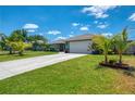 Beautiful home featuring meticulous landscaping, lovely palms, and an extended drive leading to an attached two-car garage at 9321 New Martinsville Ave, Englewood, FL 34224
