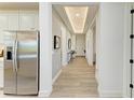 Bright and open hallway with tray ceiling and wood-look tile flooring throughout at 1007 Waterline Ct, Sarasota, FL 34240