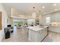 Open kitchen with large center island and modern lighting fixtures overlooking the bright living area at 1007 Waterline Ct, Sarasota, FL 34240