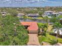 Stunning aerial view of waterfront home with red tile roof along a tranquil canal at 1038 Contento St, Sarasota, FL 34242