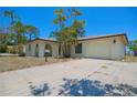 Charming single-story home with a large driveway and lush tropical landscaping, creating an inviting curb appeal at 1223 De Narvaez Ave, Bradenton, FL 34209
