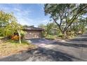 A well-maintained front yard with mature trees and an attached two-car garage at 1502 Water Oak S Way, Bradenton, FL 34209