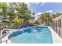 Inviting backyard pool with a diving board and a black fence surrounded by palm trees at 2049 E Leewynn Dr, Sarasota, FL 34240