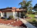 Charming townhouse with desert landscaping and a walkway leading to the front door at 2058 Sunset Point Rd # 11, Clearwater, FL 33765
