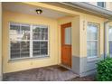 Inviting front porch with a colorful door, tiled floor, and bright windows providing natural light at 220 Coquina Bay Dr, St Petersburg, FL 33705