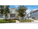 Inviting two-story home showcasing a covered front porch, complemented by mature trees and manicured landscaping at 230 Sapphire Lake Dr # 201, Bradenton, FL 34209
