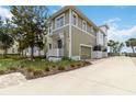 Beautiful home featuring a front porch, a garage, well-maintained landscaping, and a view of the water at 230 Sapphire Lake Dr # 201, Bradenton, FL 34209