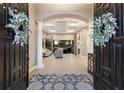 Grand foyer featuring a decorative rug, arched entryway, and coffered ceilings at 2301 Little Country Rd, Parrish, FL 34219
