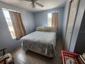Comfortable bedroom with two windows, neutral toned curtains, a ceiling fan and tile flooring at 300 N 22Nd St, Bradenton Beach, FL 34217
