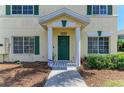 Inviting townhouse front door with decorative wreath, green trim, and well-maintained landscaping at 311 Cape Harbour Loop # 108, Bradenton, FL 34212