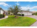 Inviting home exterior with a two-car garage, vibrant landscaping, and a well-maintained lawn at 3130 Ringwood Mdw # 44, Sarasota, FL 34235