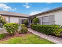 Charming single-story home with lush landscaping, manicured shrubs, and a welcoming brick walkway at 3130 Ringwood Mdw # 44, Sarasota, FL 34235