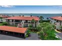 Beautiful waterfront condo with a red tile roof, lush landscaping, and convenient covered parking at 3420 Wild Oak Bay Blvd # 120, Bradenton, FL 34210