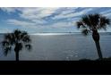 Stunning waterfront view with silhouetted palm trees against the sparkling water at 3420 Wild Oak Bay Blvd # 120, Bradenton, FL 34210
