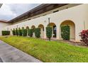 Beige two-story condominium building with arched entryways and a well-maintained grassy lawn at 3690 Pinecrest St # 114, Sarasota, FL 34232