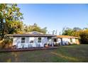Lovely single story home with deck and chairs and vibrant landscaping at 3717 Downer Ave, Sarasota, FL 34240