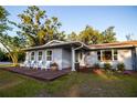 Inviting home with a cozy front porch, four chairs, fresh landscaping, and a well-manicured lawn at 3717 Downer Ave, Sarasota, FL 34240