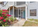 Close up of a condo with screened entry, blue door, flowering bushes, and sidewalks at 3781 59Th W Ave # 3781, Bradenton, FL 34210