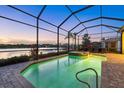 Screened pool area with hot tub and comfortable lounge chairs overlooking a tranquil lake at 3808 Eastham Ln, Bradenton, FL 34211