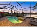 Inviting screened pool area with a relaxing spa and outdoor seating, perfect for entertaining near the lake at 3808 Eastham Ln, Bradenton, FL 34211