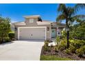 Charming single-Gathering home featuring a spacious driveway leading to a two-car garage, lush landscaping, and a welcoming front door at 4815 Deep Creek Ter, Parrish, FL 34219