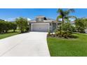 Well-kept single-Gathering home featuring a spacious driveway leading to a two-car garage and lush landscaping at 4815 Deep Creek Ter, Parrish, FL 34219
