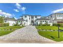 Striking modern home with lush front lawn, gorgeous landscaping, and a lengthy paver driveway at 4815 W Sunset Blvd, Tampa, FL 33629