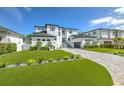 Beautiful modern home with a manicured lawn, elegant landscaping, and a long driveway at 4815 W Sunset Blvd, Tampa, FL 33629