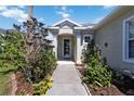 Inviting front entrance with a well-defined walkway lined by lush landscaping and a decorative front door at 5227 Aqua Breeze Dr, Bradenton, FL 34208