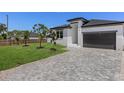 Exterior view with a paver driveway, small palm trees and green grass at 532 Yale Rd, Venice, FL 34293