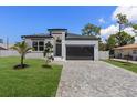 A modern home with a well-manicured lawn and dark gray accents on its exterior at 532 Yale Rd, Venice, FL 34293