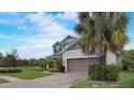 Side view of home featuring a two-car garage and well-kept lawn with landscaping at 6001 Anise Dr, Sarasota, FL 34238
