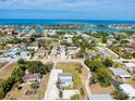An aerial perspective reveals a vibrant community by the waterfront, speckled with lush trees and well-maintained homes under a blue sky at 612 Shore Rd, Nokomis, FL 34275