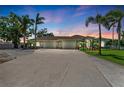 Expansive driveway leading to a three-car garage with stone accents and lush landscaping at 7420 Tuttle Ave, Sarasota, FL 34243