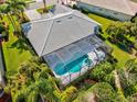 Aerial view of a beautiful home showcasing the screened pool area, well-maintained landscaping, and backyard at 7582 Camden Harbour Dr, Bradenton, FL 34212