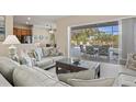 Open living room with comfortable seating, neutral colors, and sliding glass doors leading to outdoor patio at 7582 Camden Harbour Dr, Bradenton, FL 34212