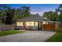 Dusk view of charming single Gathering home with a metal roof, carport and fenced yard at 815 Hand Ave, Sarasota, FL 34232
