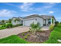Beautiful single-story home with a two-car garage, neat landscaping, and a welcoming front entrance at 10394 Abaco Falls Dr, Englewood, FL 34223