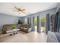 Spacious living area features a ceiling fan, neutral paint, tile flooring, and sliding glass doors to the backyard at 1122 42Nd E Ter, Bradenton, FL 34208