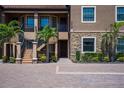 Beautiful condo exterior displaying the front doors, stone detail, and lush landscaping around the property at 12409 Osorio Ct # 102, Sarasota, FL 34238