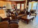 Cozy living room featuring a comfortable leather sofa, rattan accents, and a view of the backyard at 1620 San Silvestro Dr, Venice, FL 34285