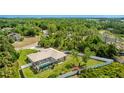 Aerial view showcasing the screened-in pool, mature trees, and fenced backyard, providing privacy at 1667 Oakland Rd, North Port, FL 34286