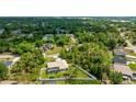 Aerial shot of a home with a screened-in pool surrounded by lush greenery and neighboring houses at 1667 Oakland Rd, North Port, FL 34286