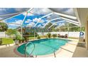 Relaxing screened-in pool area with a clear blue pool, brick trim, and comfortable seating under the lanai at 1667 Oakland Rd, North Port, FL 34286