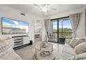 Living room featuring neutral tones, balcony access, and tile flooring at 17510 Gawthrop Dr # 208, Bradenton, FL 34211