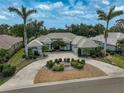 Beautiful home showcasing mature palm trees, lush landscaping, a circular driveway, and a tile roof at 2111 Muskogee Trl, Nokomis, FL 34275