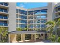 Beautiful condo building with blue accents, covered entrance, and lush tropical landscaping at 2120 Harbourside Dr # 621, Longboat Key, FL 34228