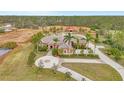 Expansive estate with a circular driveway, barn, and lush grounds showcasing Florida living at 24705 83Rd E Ave, Myakka City, FL 34251