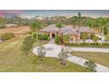 Beautiful home with a circular driveway surrounded by mature trees and manicured lawns at 24705 83Rd E Ave, Myakka City, FL 34251