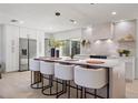 Modern kitchen island with white countertop, four barstools, and stainless steel appliances at 2720 Pinewood Ct, Clearwater, FL 33761